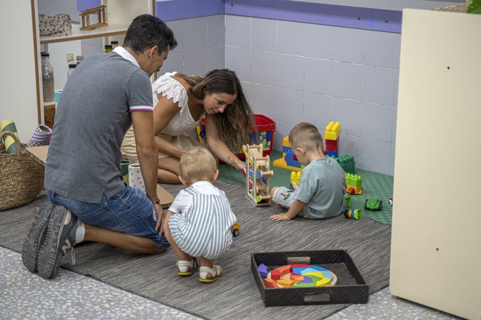 Two parents play with their children at a school in Valencia, Spain, September 12, 2022.