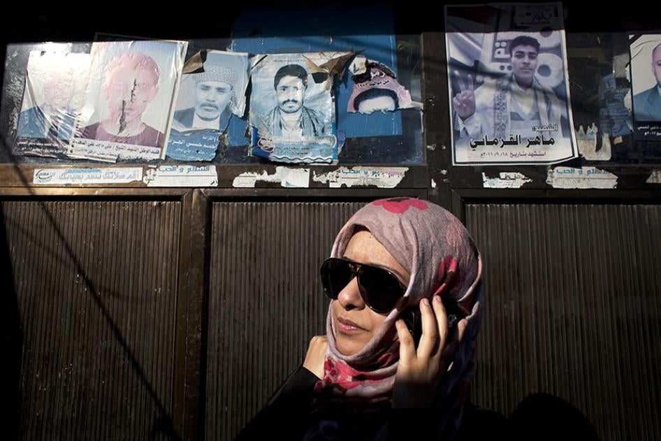 Sarah Jamal Ahmed, a 24-year-old sociologist who was one of the activists during the 2011 uprising in Sanaa, stands by posters of dead protesters posted in the streets. 