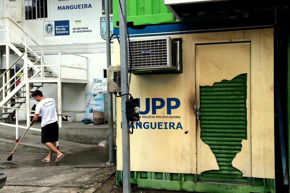 A military police officer cleans the area around the Pacifying Police Unit (UPP) at the Mangueira favela on January 14, 2016. The UPP is made of metal shipping containers. © 2016 César Muñoz Acebes/Human Rights Watch