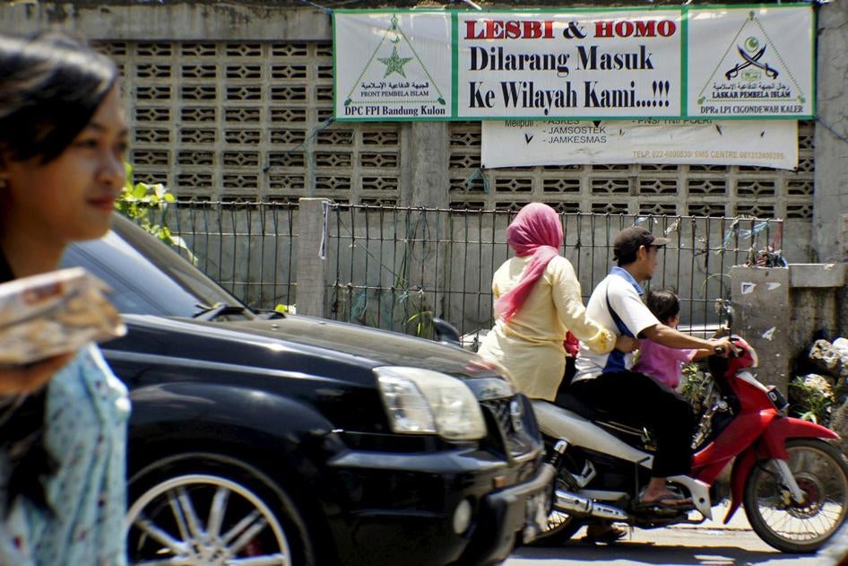 Warga mengendarai sepeda motor melewati spanduk yang dipasang oleh Front Pembela Islam yang meminta para gay meninggalkan wilayah Cigondewah Kaler di Bandung, Jawa Barat, Indonesia, 27 Januari 2016, di foto yang diambil oleh Antara Foto. Kota terbesar ket