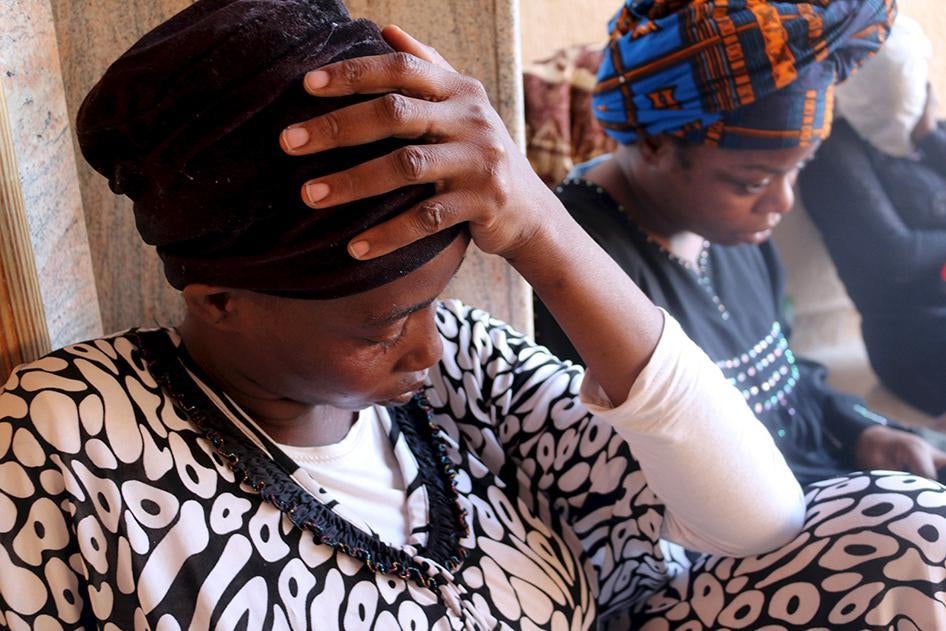 Migrants sit at a detention center in Tripoli after they were detained by the Libyan authorities on September 17, 2015.