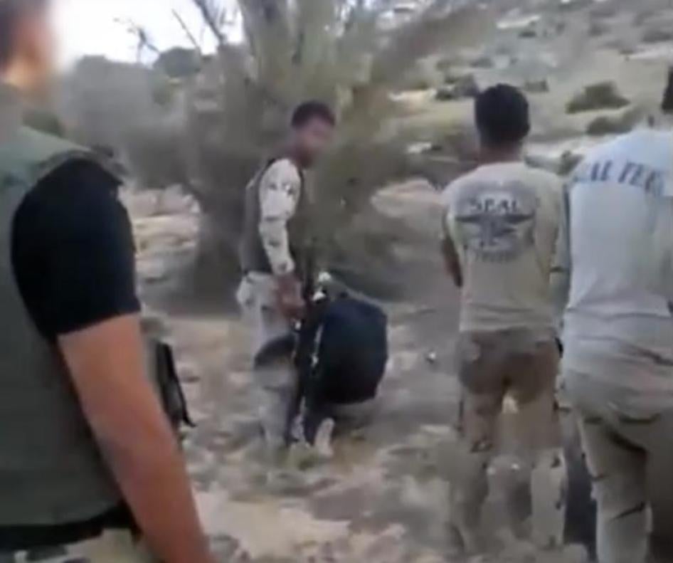 3) A member of a military-backed militia prepares to execute the second detainee. © 2017 Mekameleen