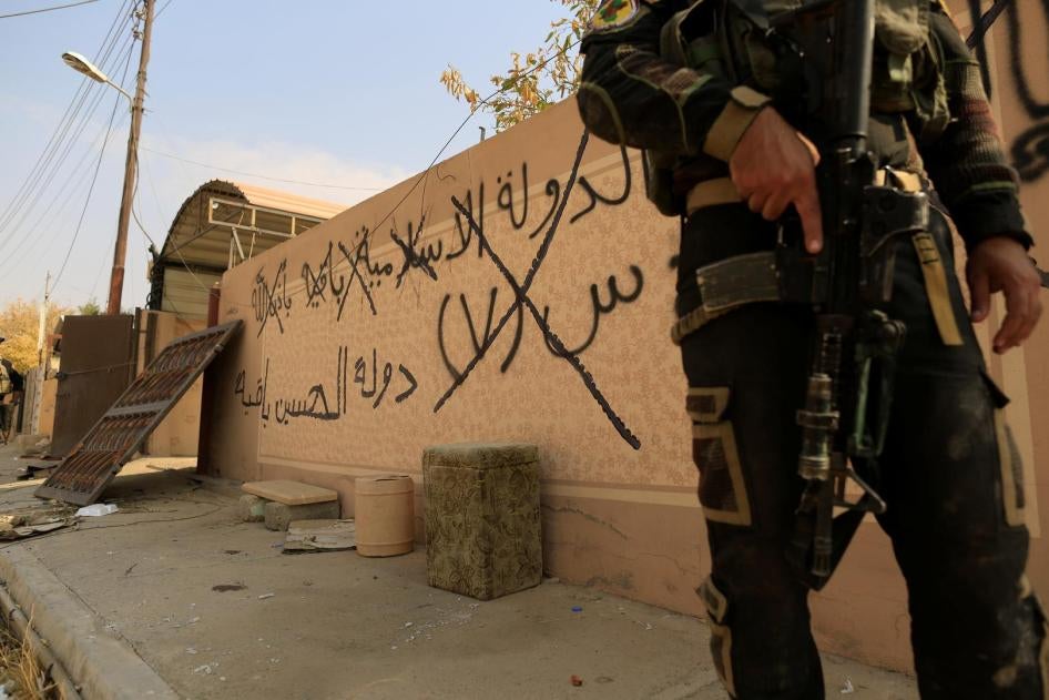An Iraqi special forces soldier stands beside graffiti, which reads: "The Islamic State will remain", in Bartalla, east of Mosul, Iraq October 27, 2016. . © 2016 Reuters
