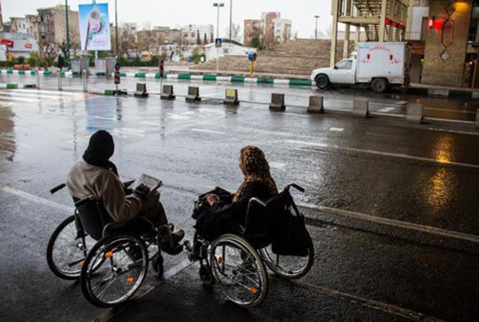 Two women who use wheelchairs attempting to cross a road in Tehran, the capital of Iran. 