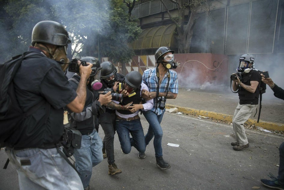 Journalists assist fellow reporter Gregory Jaimes who was injured after being shot by police officers near the La Carlota airbase during clashes with anti-government protestors in Caracas, Venezuela, Wednesday, May 1, 2019.