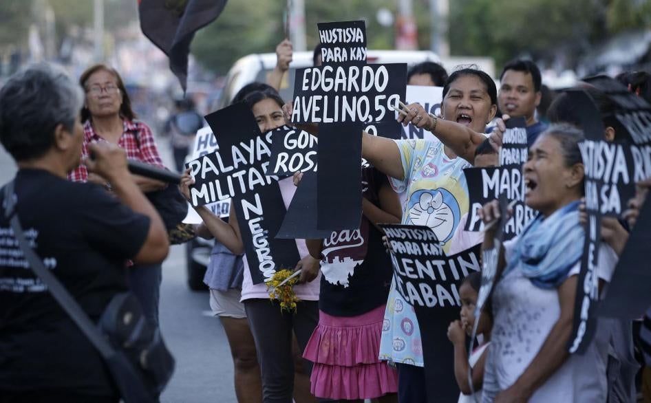 Supporters shout slogans as they hold paper crosses bearing names of killed people from Negros Oriental province during a rally in metropolitan Manila, Philippines on Monday, April 8, 2019.