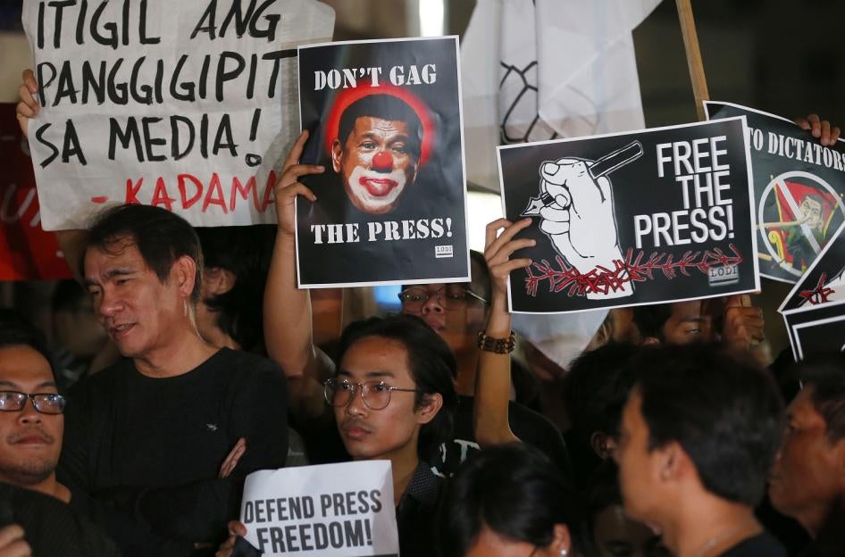 Journalists and supporters, wearing black, display their messages during a protest against the recent Securities and Exchange Commission's revocation of the registration of Rappler, an online news outfit, Friday, Jan. 19, 2018, northeast of Manila, Philip