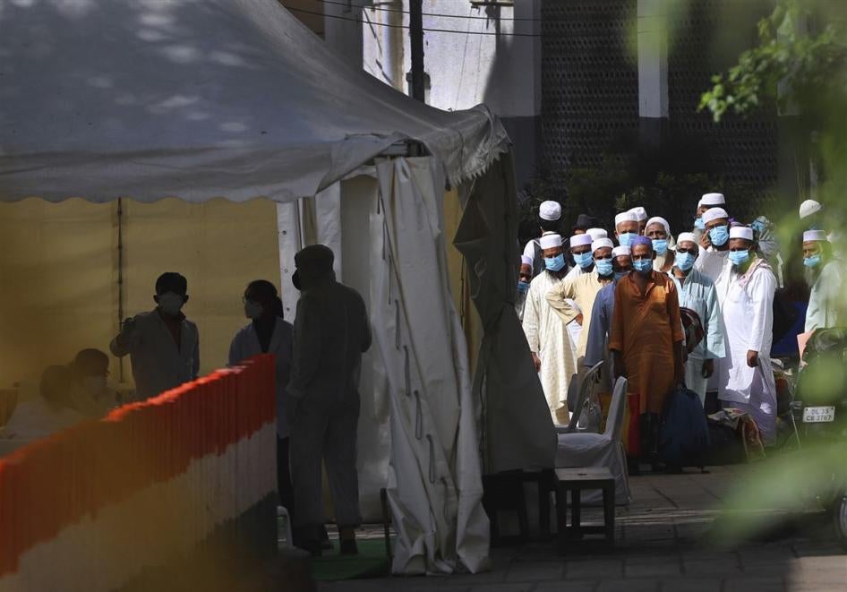 Men wait for a bus that will take them to a quarantine facility in the Nizamuddin area of New Delhi, India, March 31, 2020.