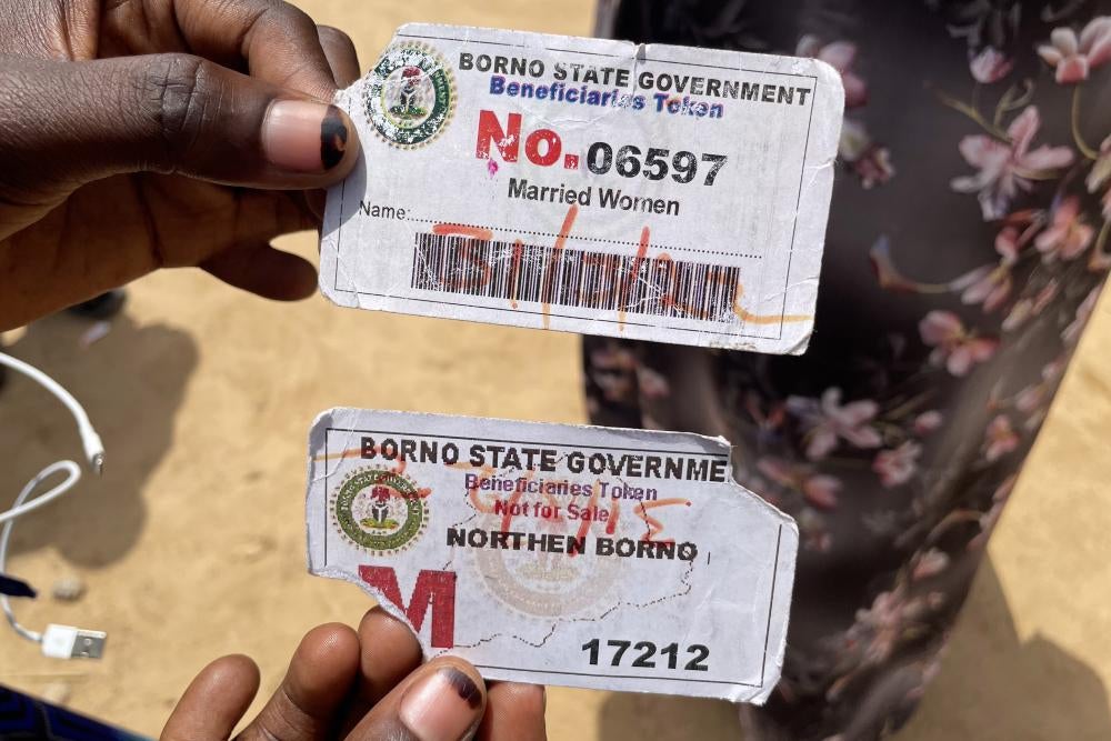 A person holds up two paper cards