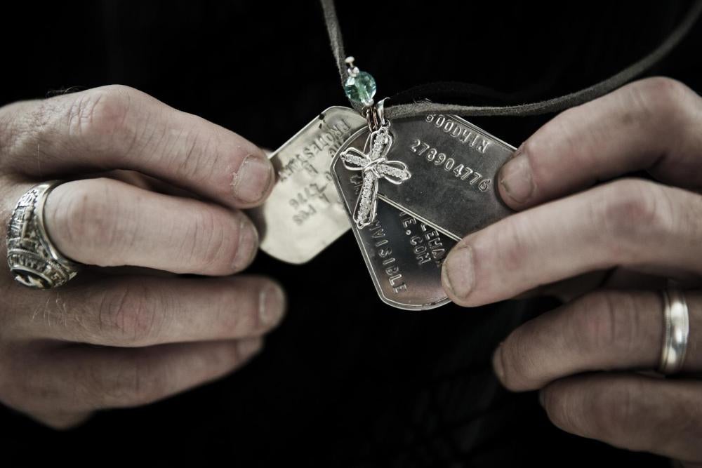 Gary Noling holding dogtags belonging to his daughter, Carri Goodwin, a rape victim who died of acute alcohol intoxication less than a week after receiving an Other Than Honorable discharge from the Marines. Because of her discharge, her father has been u