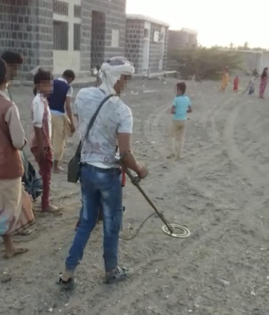 عامل في إزالة الألغام مع أطفال يتبعونه في بلدة في الساحل الغربي. © 2018 خاص