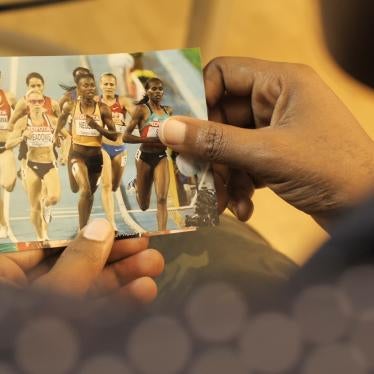 A woman holds a photo of a group of female runners competing
