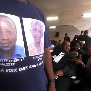 A man wearing a T-shirt with portraits of Floribert Chebeya and Fidèle Bazana attends the trial in Kinshasa on April 30, 2013 of policemen accused of killing the two men in 2010.