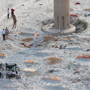 Policeman stand bodies Ganges River India Covid