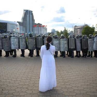 A woman wearing white stands in front of riot police during a Belarusian opposition rally protesting the official presidential election results in Minsk, Belarus, September 13, 2020. 