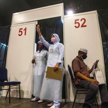 A health worker gestures to the next vaccine recipient at Malaysia International Trade & Exhibition Centre in Kuala Lumpur, Malaysia on May 31, 2021.