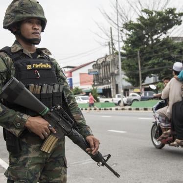 A uniformed police officer holding a gun next to a street