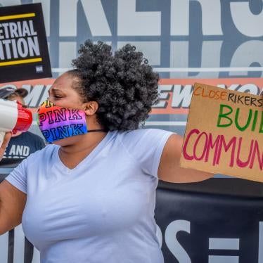 A participant holds a “Build Communities” sign at a rally on Rikers Island in New York, NY. 