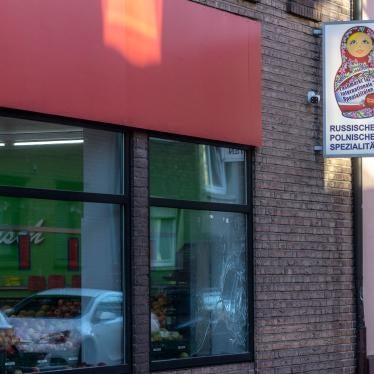 A smashed window pane and smeared white paint are seen on a Russian-Polish supermarket