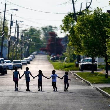 Children walk hand in hand down a street