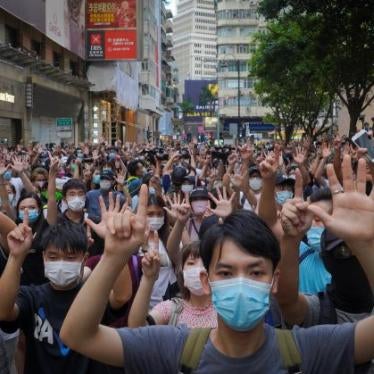 A crowd of protesters holding up five fingers on one hand, and one finger on the other hand.