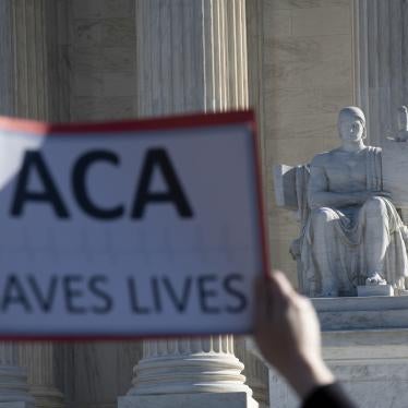 A protester holds up a sign that says "ACA saves lives"