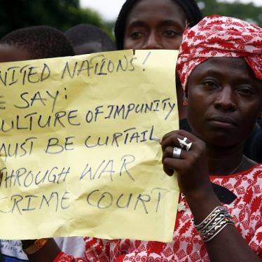 A woman holds a placard during a peaceful demonstration in the Liberian capital Monrovia, July 4, 2006, calling on the visiting U.N. Secretary General Kofi Annan to establish a war Crimes court in Liberia as a means to bring justice to the country. 