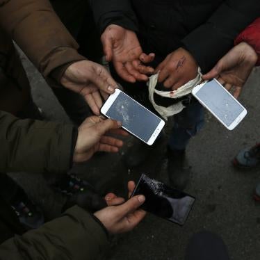 Migrants show broken phones in the village of Horgos, Serbia