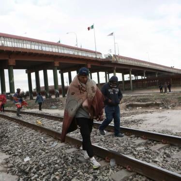 Venezuelans walk near a bridge that crosses the Rio Grande River after being expelled from the United States