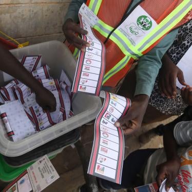 Independent National Electoral Commission officials sort and count ballots at a polling station in Kano during Nigeria's election.