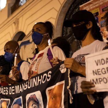 People gathered in a protest against police violence and structural racism hold signs, one of them reading "Black Lives Matter"