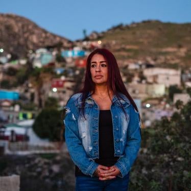 A woman standing in front of a blurred cityscape
