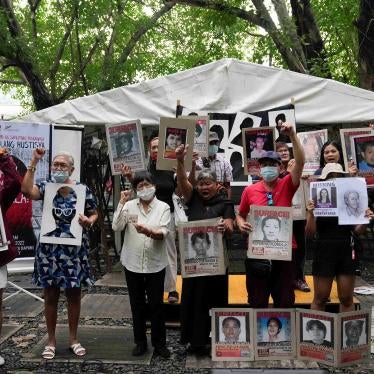 A group of people hold placards and shout slogans at a protest