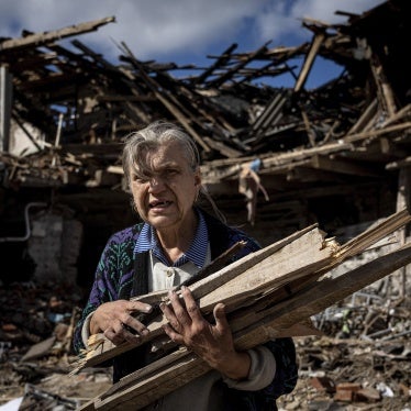 Женщина собирает дрова для отопления в разрушенном здании школы, в котором базировались российские военнослужащие в городе Изюм (Украина), 19 сентября 2022 года.