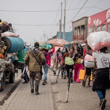 A Wazalendo fight joins residents fleeing Kibati, DRC.