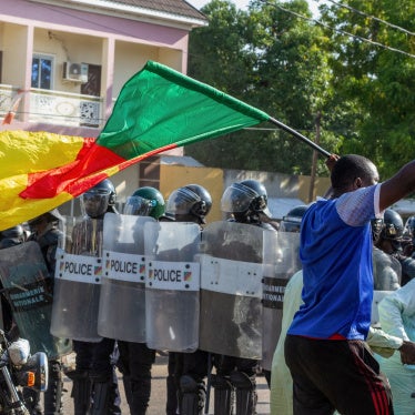 A protester waving a Cameroonian flag approaches police officers as they gather in Garoua on October 26, 2025.