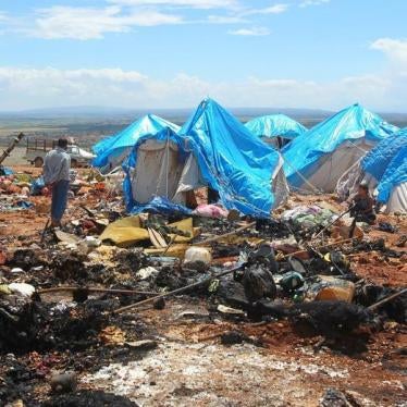 People stand near the damage after air strikes on May 5 hit a camp for internally displaced people in Syria's Idlib province near the Turkish border, May 7, 2016.