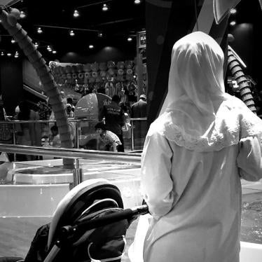 A migrant domestic worker watches over a child playing in the Magic Planet, City Centre Muscat, a shopping mall in Oman.