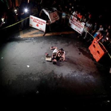Jennelyn Olaires, 26, weeps over the body of her partner, who was killed on a street by a vigilante group, according to police, in a spate of drug related killings in Pasay city, Metro Manila, Philippines July 23, 2016. A sign on a cardboard found near th