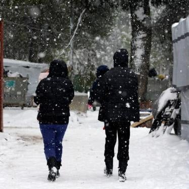 Stranded Syrian refugees carry their children through a show storm at a refugee camp north of Athens, Greece January 10, 2017.