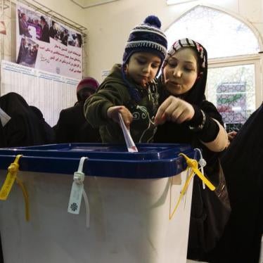 A woman lets her child cast her ballot during the parliamentary election, at a mosque in southern Tehran March 2, 2012.