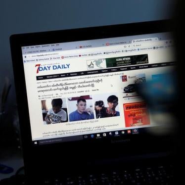 A reporter looks at an article about the three detained journalists in the Democratic Voice of Burma newsroom in Rangoon, Burma, June 29, 2017.