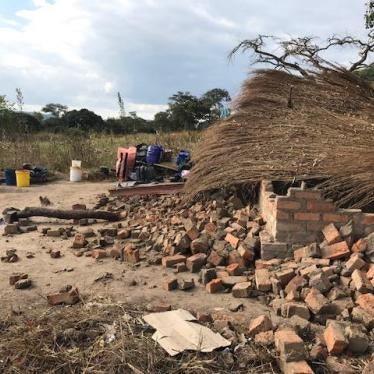 Two women clean pots and plates in front of the remains of their demolished house at Arnolds Farm, Mazowe. Anti-riot police, who claim the farm is owned by the First Family, demolished the house on May 9, 2017, despite two court orders prohibiting the dem