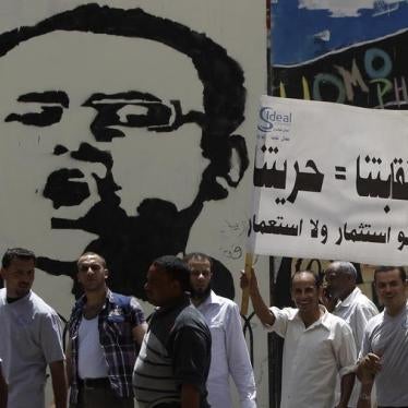 Workers holding a banner shout slogans against the government during a protest near Tahrir Square in Cairo, Egypt on April 29, 2013. 