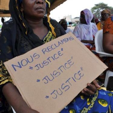 Pancarte tenue par une femme ivoirienne lors d’une manifestation à Abidjan le 28 février 2013, alors que se tenait à la Cour pénale internationale, à La Haye, l’audience de confirmation des charges contre l’ex-président Laurent Gbagbo. 