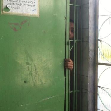 A man with disabilities looks out through the bars of a psychiatric ward in an institution in Rio de Janeiro. Persons locked in this section of the institution never left their rooms, according to staff.