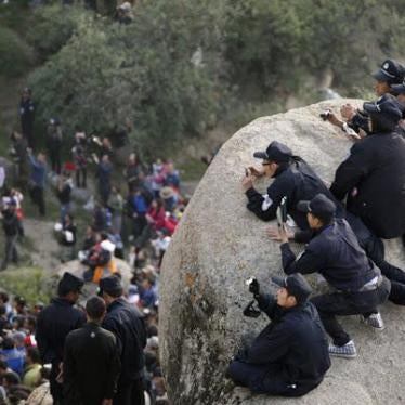 Chinese police photograph the crowd at the ceremonial unfolding of a giant thangka, or religious silk embroidery, during the Shoton Festival at Drepung Monastery on the outskirts of Lhasa, Tibet Autonomous Region, August 29, 2011.
