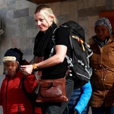 A member of a nongovernmental organization accompanies two children and their mother (right) out of a northeastern Syria camp for wives and children of Islamic State members, January 21, 2019. (Faces blurred by Getty Images.) © 2019 Delil Souleiman/AFP/Ge