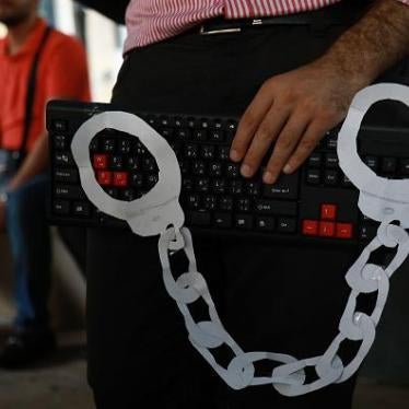 An activist holds a computer keyboard and makeshift handcuffs in downtown Beirut on July 24, 2018, during a protest against the recent wave of interrogations by Lebanese security forces of people making political comments online. 