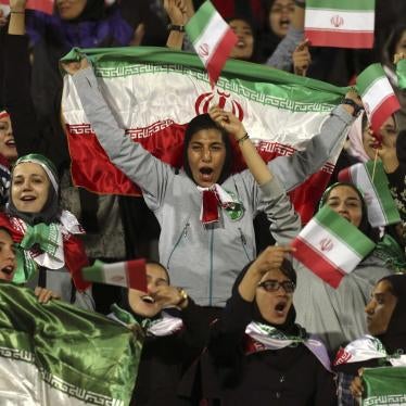 Female Iranian spectators cheer as they wave their country's flag during a friendly soccer match between Iran and Bolivia, at the Azadi (Freedom) stadium, in Tehran, Iran, Tuesday, Oct. 16, 2018.